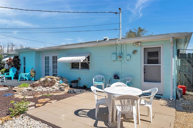 rear view of property with a patio area and concrete block siding