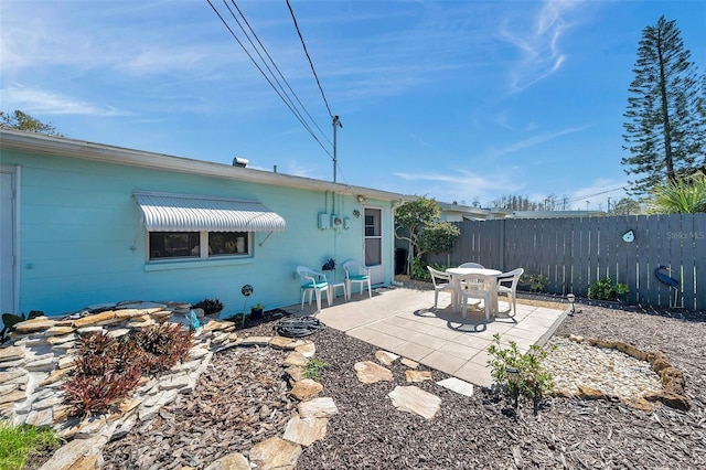 rear view of property with fence and a patio