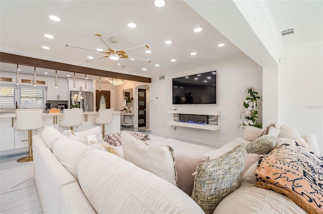 living room with recessed lighting, visible vents, arched walkways, and ornamental molding