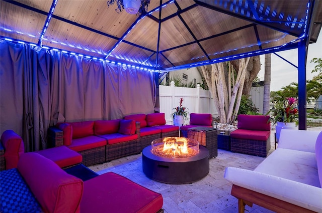 view of patio featuring a gazebo, an outdoor living space with a fire pit, and fence