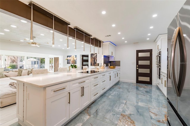 kitchen with visible vents, open floor plan, freestanding refrigerator, white cabinets, and black electric cooktop