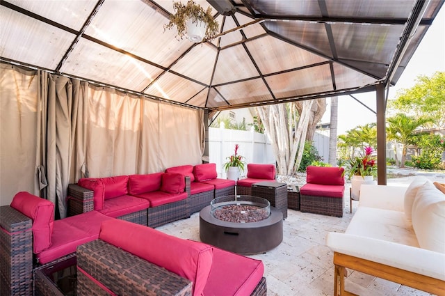 view of patio / terrace featuring an outdoor living space with a fire pit, a gazebo, and fence