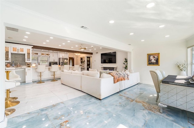 unfurnished living room with recessed lighting, visible vents, marble finish floor, and ornamental molding