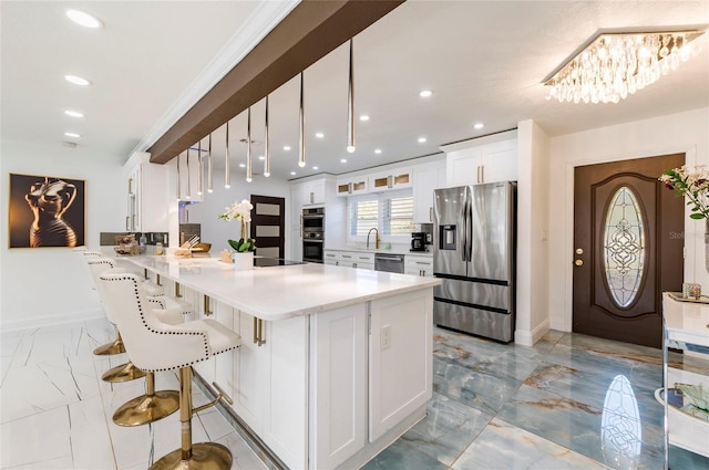 kitchen featuring marble finish floor, a breakfast bar, white cabinetry, stainless steel appliances, and a peninsula