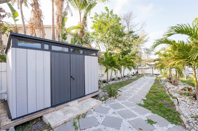 view of yard featuring an outdoor structure, a storage unit, and fence