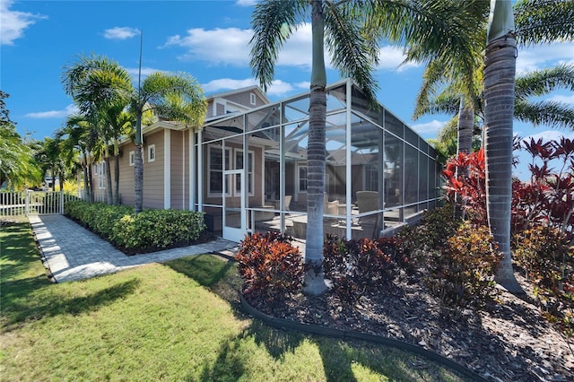 5616 Seagrass Pl, Apollo Beach, FL 33572 - view of side of property featuring glass enclosure, a lawn, and fence