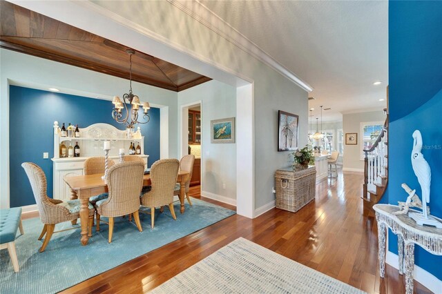 5616 Seagrass Pl, Apollo Beach, FL 33572 - dining area with hardwood / wood-style flooring, stairs, ornamental molding, and a notable chandelier