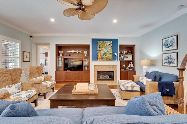 5616 Seagrass Pl, Apollo Beach, FL 33572 - living room with built in shelves, light wood finished floors, recessed lighting, ornamental molding, and a glass covered fireplace