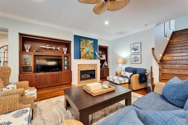 5616 Seagrass Pl, Apollo Beach, FL 33572 - living area featuring stairway, a premium fireplace, ornamental molding, a ceiling fan, and wood finished floors