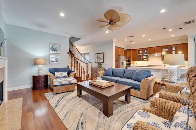 5616 Seagrass Pl, Apollo Beach, FL 33572 - living room featuring a high end fireplace, visible vents, ornamental molding, stairway, and light wood finished floors