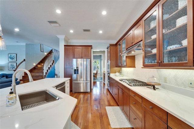 5616 Seagrass Pl, Apollo Beach, FL 33572 - kitchen with visible vents, appliances with stainless steel finishes, crown molding, light wood-type flooring, and a sink