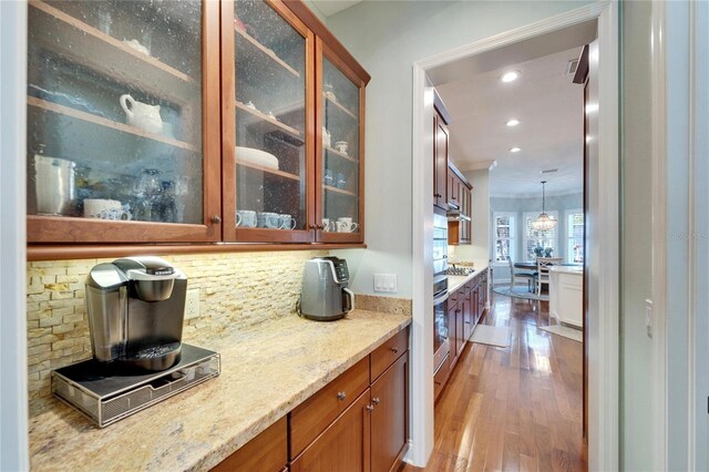 5616 Seagrass Pl, Apollo Beach, FL 33572 - bar with pendant lighting, recessed lighting, backsplash, wood finished floors, and oven