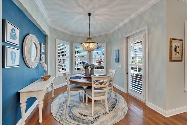 5616 Seagrass Pl, Apollo Beach, FL 33572 - dining room with crown molding, baseboards, a notable chandelier, and wood finished floors