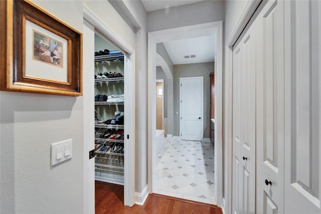 5616 Seagrass Pl, Apollo Beach, FL 33572 - hall featuring visible vents, arched walkways, and wood finished floors