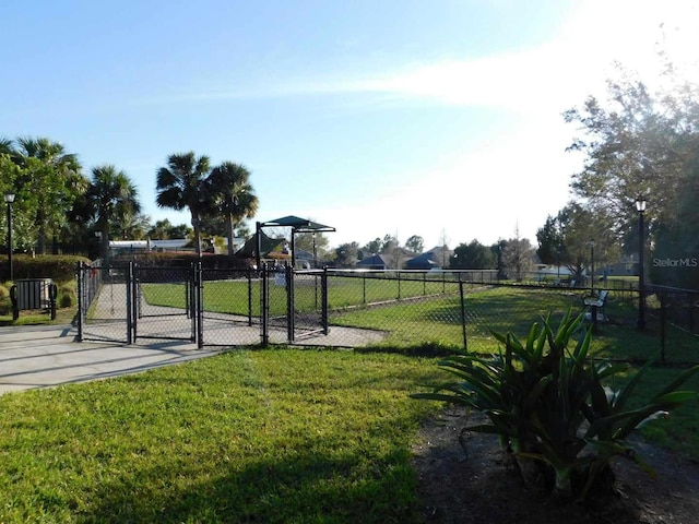 view of community featuring a yard, fence, and a gate