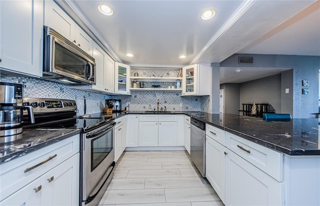 kitchen with open shelves, glass insert cabinets, decorative backsplash, appliances with stainless steel finishes, and a sink