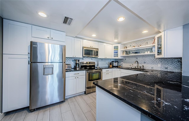 kitchen with visible vents, open shelves, a sink, stainless steel appliances, and white cabinets