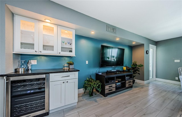 bar with visible vents, baseboards, beverage cooler, and a dry bar