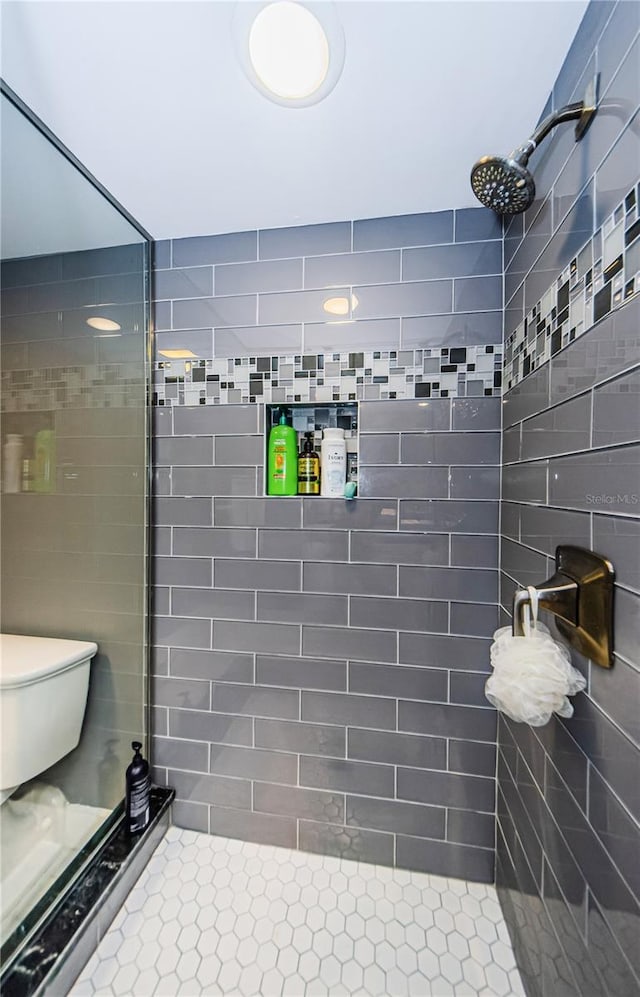 bathroom featuring toilet and a tile shower