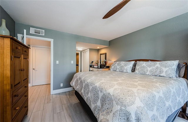 bedroom with visible vents, baseboards, a ceiling fan, and light wood finished floors