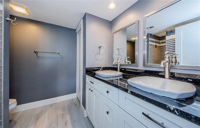 full bathroom with a sink, curtained shower, toilet, and visible vents