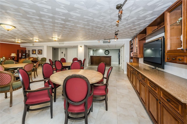 dining room featuring track lighting, light tile patterned flooring, and visible vents