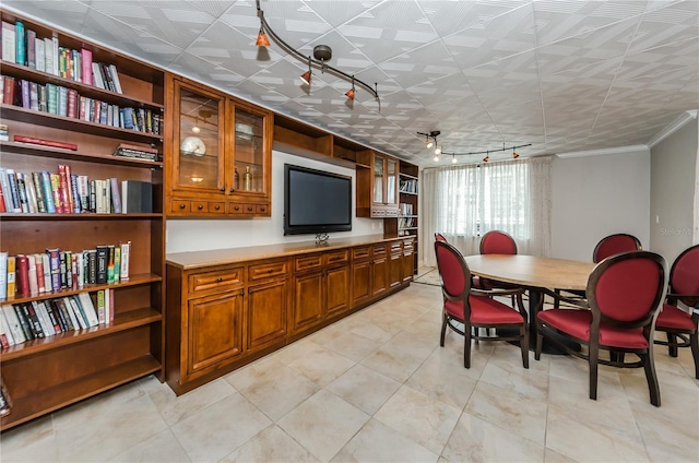 dining area featuring crown molding and rail lighting