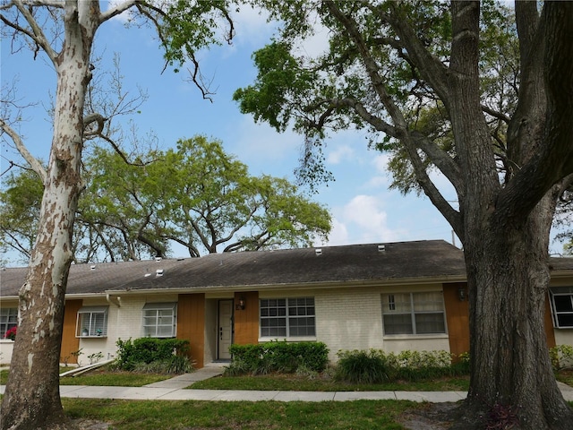 view of front of house with roof with shingles and brick siding