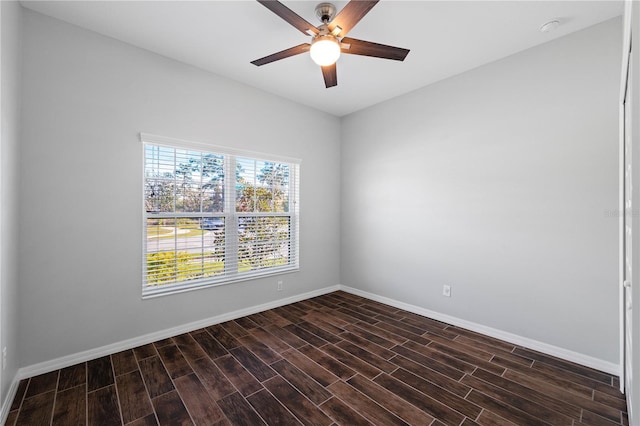 spare room featuring dark wood finished floors, baseboards, and ceiling fan