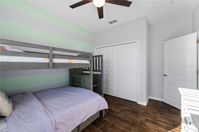 bedroom with a closet, wood finished floors, visible vents, and baseboards