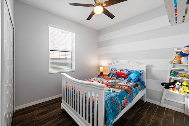 bedroom with a ceiling fan, wood finish floors, and baseboards