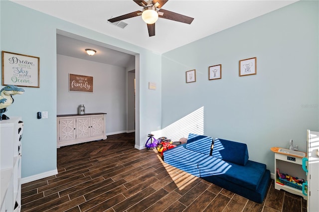 playroom featuring wood finish floors, a ceiling fan, and baseboards