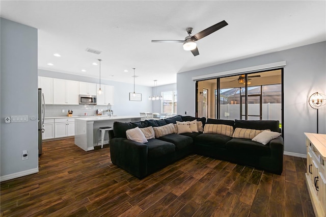 living room with recessed lighting, baseboards, dark wood-style flooring, and ceiling fan with notable chandelier