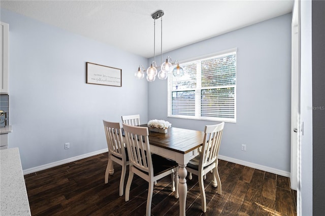 dining area featuring dark wood-type flooring and baseboards