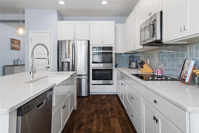 kitchen featuring dark wood-style floors, white cabinetry, stainless steel appliances, and backsplash