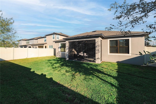 back of house featuring a yard, fence, and stucco siding