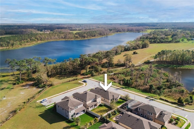 drone / aerial view featuring a water view and a wooded view