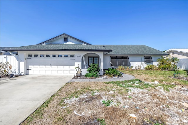 ranch-style home with driveway, a garage, roof with shingles, fence, and stucco siding