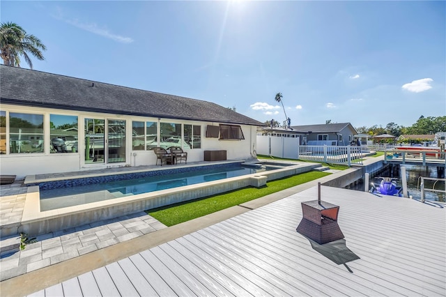 back of house with an outdoor pool and fence