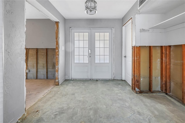 entrance foyer with french doors and unfinished concrete floors