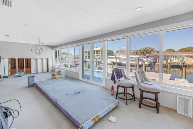 sunroom / solarium with a water view and visible vents