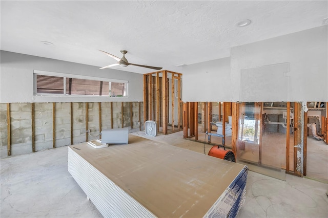 interior space featuring a ceiling fan and a textured ceiling