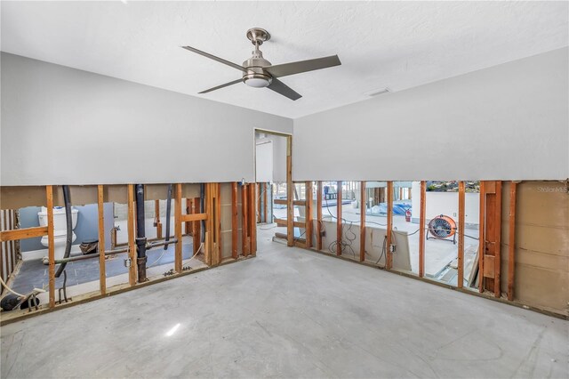 unfurnished room with ceiling fan, visible vents, and concrete flooring