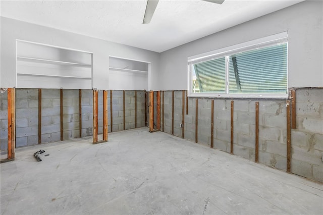 spare room with concrete floors and concrete block wall