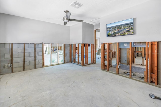 empty room featuring concrete flooring, ceiling fan, visible vents, and concrete block wall