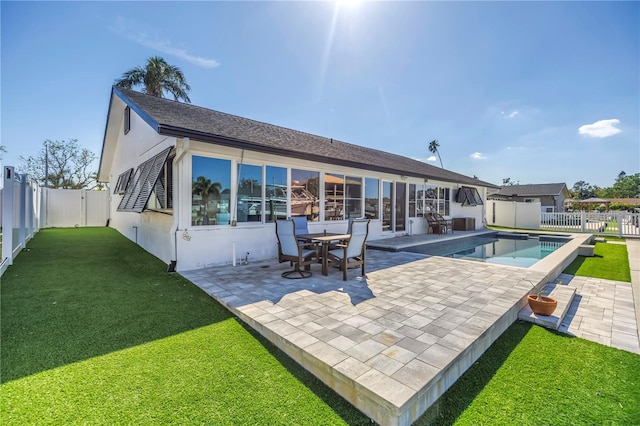 rear view of house with a fenced in pool, a lawn, a patio, a fenced backyard, and stucco siding