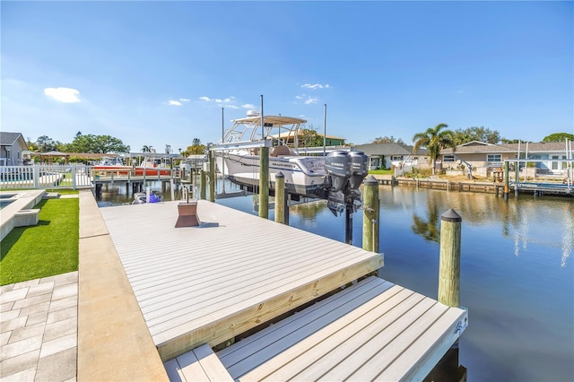 dock area featuring a water view, boat lift, a residential view, and fence