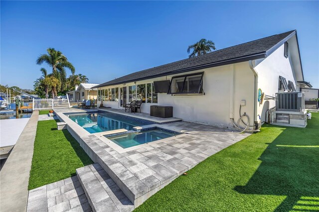 outdoor pool featuring a patio, central AC unit, an in ground hot tub, fence, and a lawn