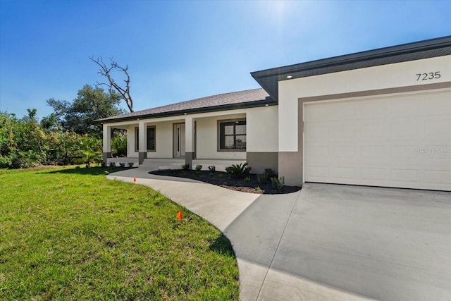 view of front facade with an attached garage, a front lawn, concrete driveway, and stucco siding