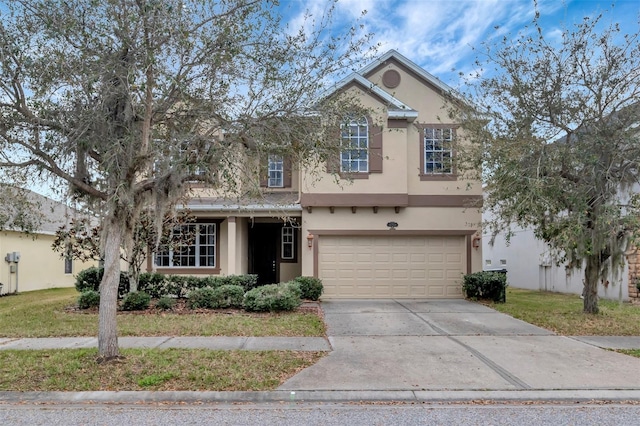 traditional-style house featuring driveway, an attached garage, and stucco siding